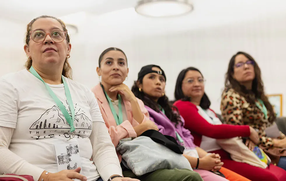 Fila de participantes atentas durante una actividad