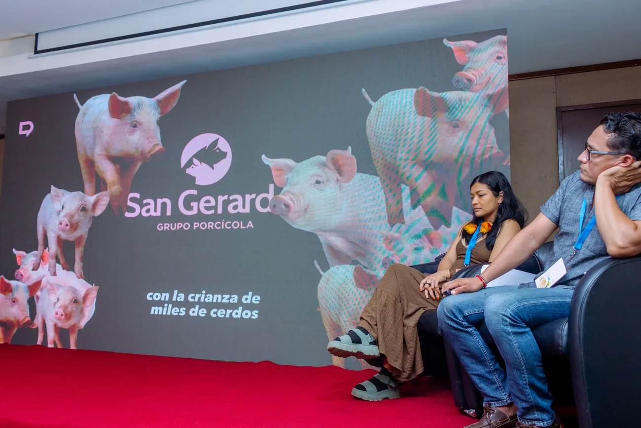 Panel sobre granjas industriales con la presentación proyectada detrás