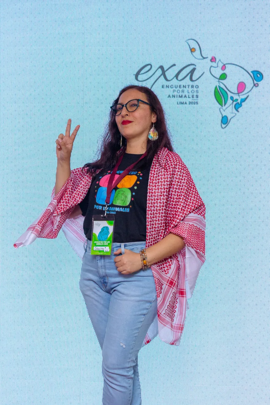Participante posa frente al logo de EXA Lima 2025