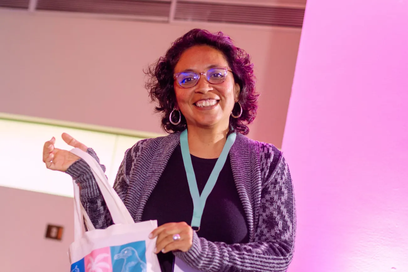 Participante sonríe mostrando una bolsa de tela de EXA